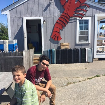 Smitty's State Pier Lobster Pound - a man and a boy sitting in front of a lobster shack - Seafood Markets Near Me - Hampton, New Hampshire Smitty's State Pier Lobster Pound - a man and a boy sitting in front of a lobster shack - Seafood Markets Near Me - Hampton, New Hampshire