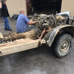Ray's Garage - That's the boss and a technician rolling in the frame fully set up to go without any body or seats.