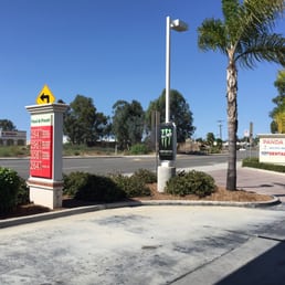 a parking lot with a sign and palm trees a parking lot with a sign and palm trees