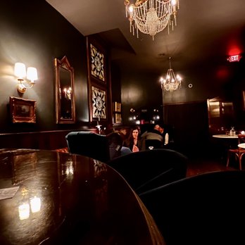 Conway Social Club - a man sitting in a chair in a dimly lit room - Cocktail Bars Near Me - Lancaster, Pennsylvania Conway Social Club - a man sitting in a chair in a dimly lit room - Cocktail Bars Near Me - Lancaster, Pennsylvania