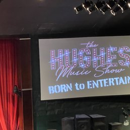 a stage with red curtains and a projector screen a stage with red curtains and a projector screen