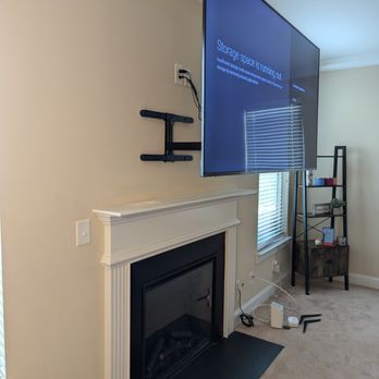 TekOnSite - Full motion TV mounted on the fireplace - Security Systems Near Me