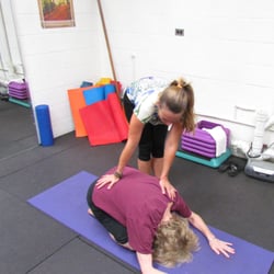 Yoga By Thais - Thais assisting student.