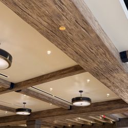 Bare beam ceilings and soft metal fixtures light the inside of this modern French country decor.