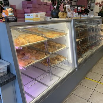 Donut House - A glass display case filled with various baked goods, including croissants, pastries, and donuts, at Donut House in Redding, CA. - Donuts Near Me - Redding, California