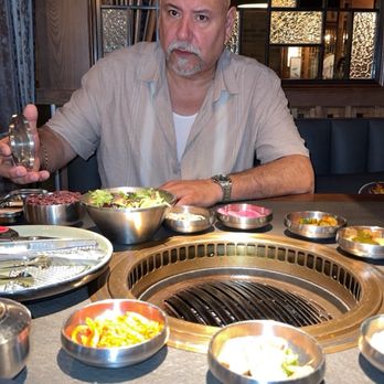Wu's Korean BBQ - A fresh assortment of traditional banchan perfectly placed right in front of my straight-faced husband. - Barbeque Near Me - Chicago, Illinois Wu's Korean BBQ - A fresh assortment of traditional banchan perfectly placed right in front of my straight-faced husband. - Barbeque Near Me - Chicago, Illinois