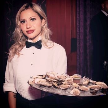 Chez Parée - a woman holding a tray of oysters - Strip Clubs Near Me - Montreal, Quebec