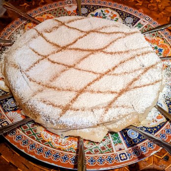 Marrakesh Restaurant - The B'stella - Layered pie with chicken, nuts, eggs, parsley and onions, topped with confection sugar and traced with cinnamon - Moroccan Near Me - Philadelphia, Pennsylvania