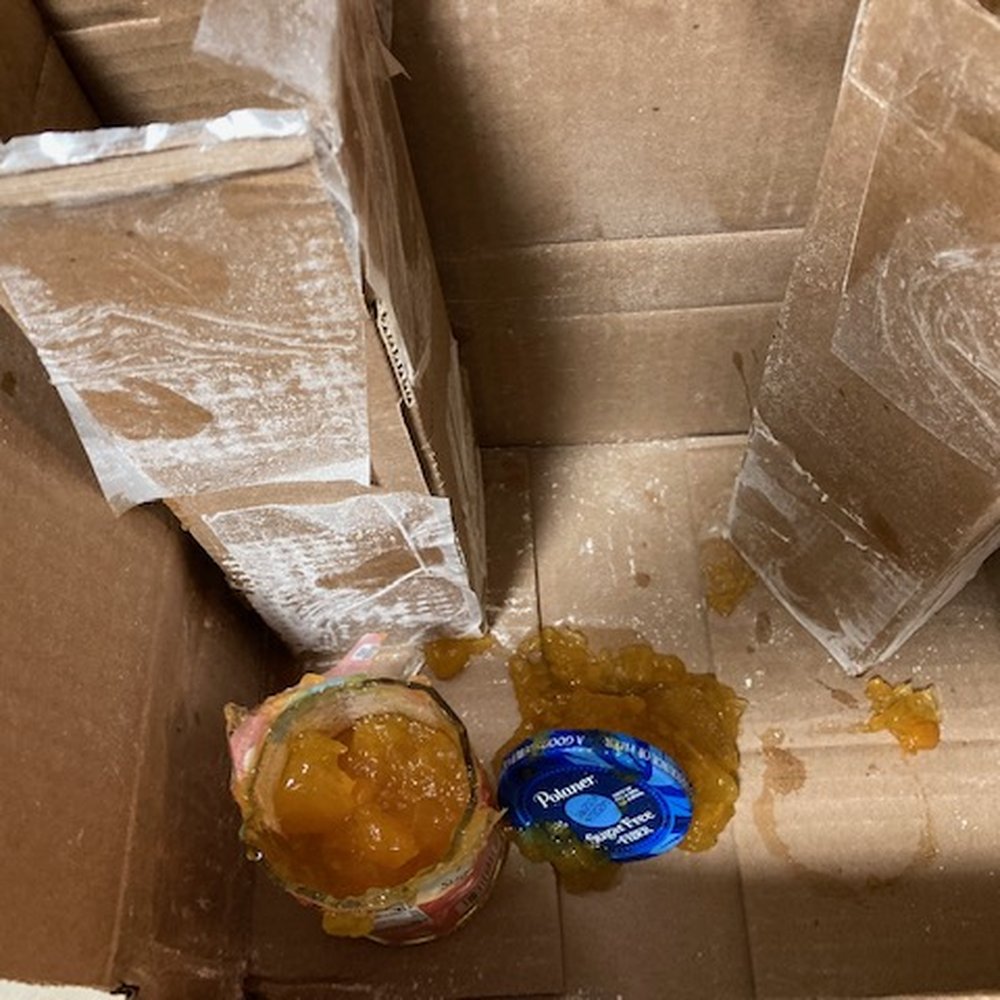 Jelly jars stacked end to end in cardboard, but no packing at ends, or between bottles.  Not shown, a ruptured bag of flour