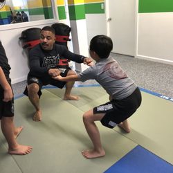 Charles Gracie San Mateo Academy - Cristiano hands on with the kids getting in their strength training.