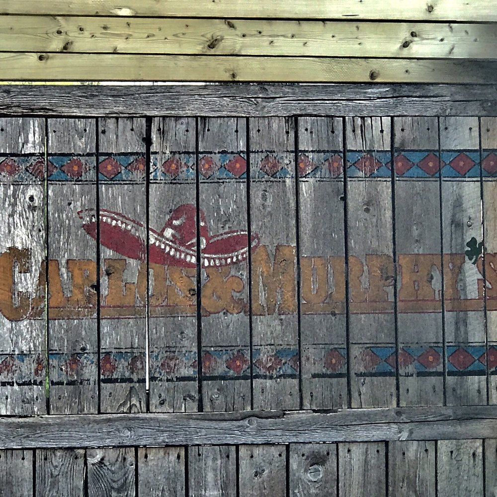 Carlos & Murphy's - a sign on a wooden door - Mexican Near Me - Winnipeg, Manitoba