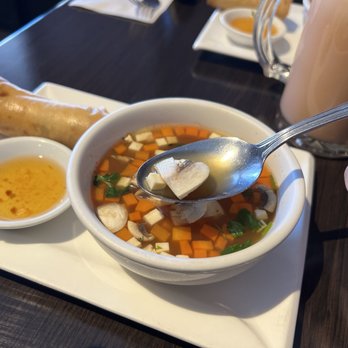 Thai Coconut Restaurant - a person holding a spoon over a bowl of soup - Thai Near Me - Burlington, Ontario