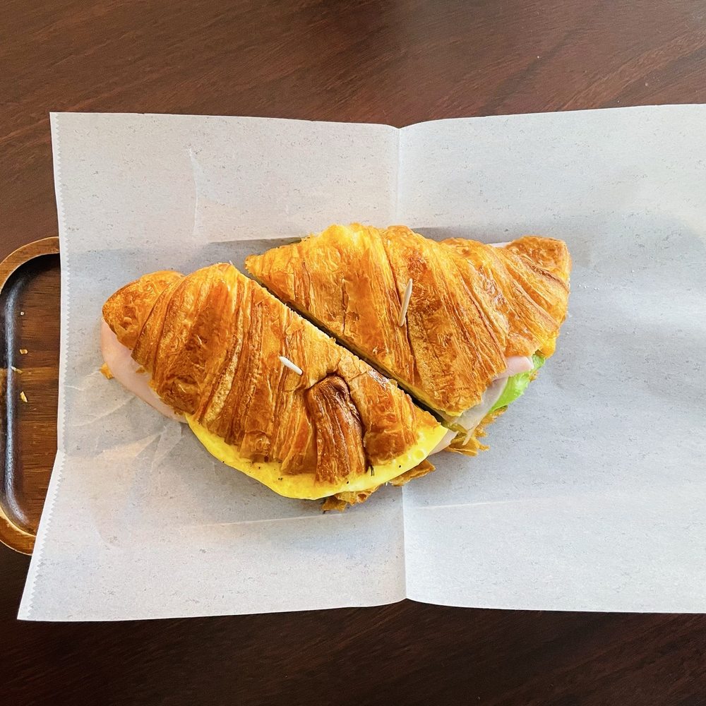 Kuma cafe - Croissant Sandwich (Ham, Egg, Cheddar, Avocado, Garlic Aioli on an Artisan Croissant). - Coffee & Tea Near Me - San Diego, California