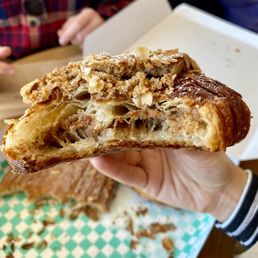 Inside of twice-baked pecan + oat croissant-- filled and topped with to-die-for filling that makes it almost like biting into a pecan pie