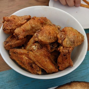 Beaches Brewing - a bowl of chicken wings and a plate of pizza - Brewpubs Near Me - Toronto, Ontario