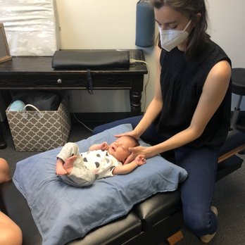 Green Stork Chiropractic - Dr Emma performing an infant adjustment, you're never too young for chiropractic care - Chiropractors Near Me - Petaluma, California Green Stork Chiropractic - Dr Emma performing an infant adjustment, you're never too young for chiropractic care - Chiropractors Near Me - Petaluma, California