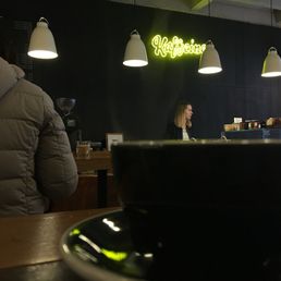 Americano in a black mug.... highlighted by the beautiful Kaffeine neon sign.