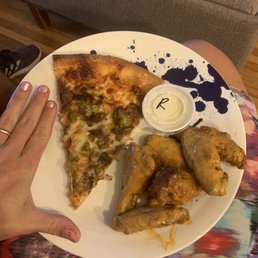 Slice of philly cheese pizza and saucy wings