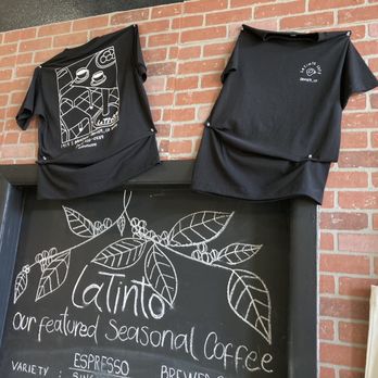 LaTinto Cafe - a chalkboard with t - shirts on it - Latin American Near Me - Denver, Colorado
