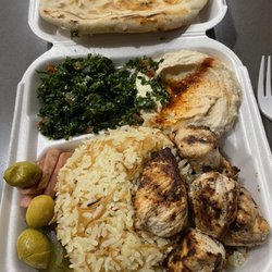 Chicken kebab plate with hummus, tabbouleh and pita bread.