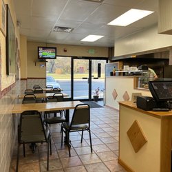 Delizia Pizza - Kitchen, TV, seating, pizza display, interior