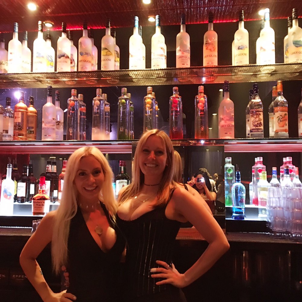 two women standing in front of a bar two women standing in front of a bar