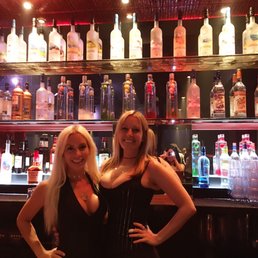 two women standing in front of a bar two women standing in front of a bar