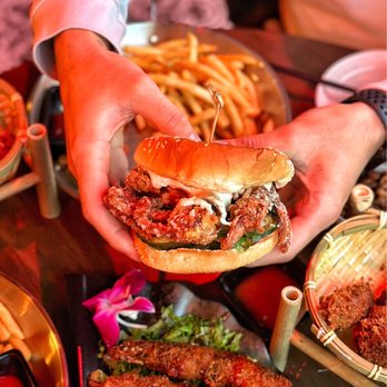 Imperial Kitchen and Bar - a person holding a burger - Cocktail Bars Near Me - Seattle, Washington