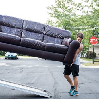 Sweeps - a man and a woman moving a couch - Movers Near Me