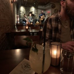 a man sitting at a table with a drink a man sitting at a table with a drink
