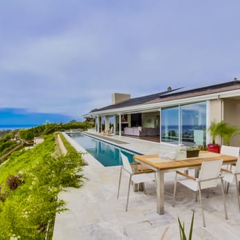 Rockstar Builders - a patio with a table and chairs overlooking the ocean - General Contractors Near Me - San Diego, California Rockstar Builders - a patio with a table and chairs overlooking the ocean - General Contractors Near Me - San Diego, California