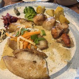 Brill filler and scallops with vegetables and potatoes.