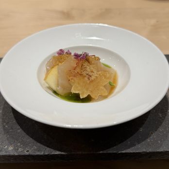Two Nine - A plated dish featuring sashimi with garnishes, edible flowers, and crispy star-shaped elements, served on a white plate. - Sushi Bars Near Me - Washington, DC, District of Columbia