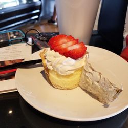 Hard Bean Coffee - Cheese cake cup with whipped cream and strawberries unwrapped.
