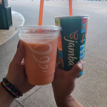 Jamba - a person holding two cups of juice - Juice Bars & Smoothies Near Me - Woodburn, Oregon