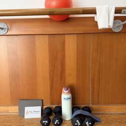 A barre spot with weights, ball, and a consent card.
