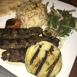 Shish Kafta dinner with rice and grilled tomato and onion. Also a little onion and parsley salad Shish Kafta dinner with rice and grilled tomato and onion. Also a little onion and parsley salad