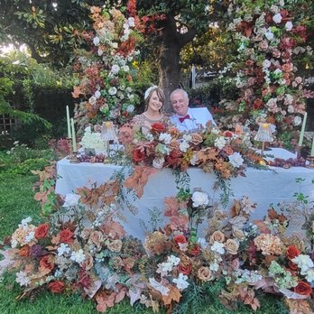Eviaire Events - Bride and husband seated at the "Sweetheart table" which is adorned with florals. - Balloon Services Near Me - San Jose, California