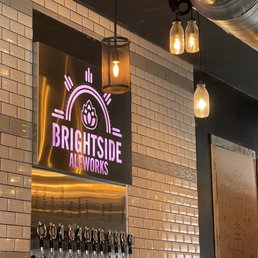 a beer tap with a neon sign above it