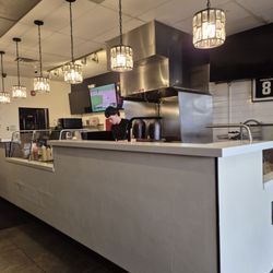 Louie’s Smash N Grill - Clean counters, floors areas, bright decorative lights and Grill Chef in background at Louie's Smash N Grill.  5/2/2026
