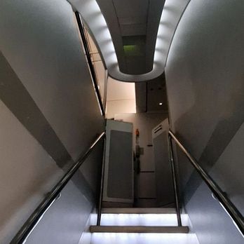 Lufthansa - Things are looking up! From the cluster of restrooms and crew area, it's back upstairs to one's economy seat in the A340-600 ... very cool! - Airlines Near Me Lufthansa - Things are looking up! From the cluster of restrooms and crew area, it's back upstairs to one's economy seat in the A340-600 ... very cool! - Airlines Near Me