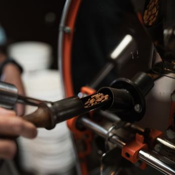 Imua Coffee Roasters - a close up of a person using a coffee roaster - Coffee & Tea Near Me - Kapaa, Hawaii