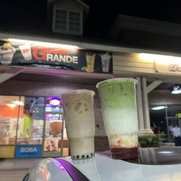 Large Lavender milk tea with boba, and Large Strawberry Matcha Milk Tea with Egg Custard in front of Boba Grande entrace