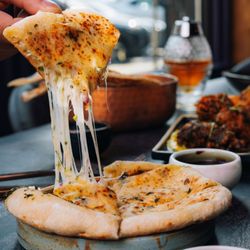 Kama - Wicker Park - Oaxaca Cheese Chili Kulcha -- KAMA's signature cheesy, spicy kulcha, baked until golden and perfect for sharing at KAMA Wicker Park.
