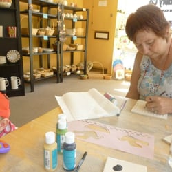 Pottery - My grandmother painting. In the background are some of the pieces you may paint and examples of completed work.