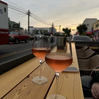 Art Du Vin - Natural Wine Bar - two wine glasses on a wooden table - Wine Bars Near Me - Long Beach, California Art Du Vin - Natural Wine Bar - two wine glasses on a wooden table - Wine Bars Near Me - Long Beach, California