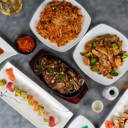 A vibrant spread of Thai and sushi favorites, featuring savory stir-fried noodles, tender beef dishes, and fresh, handcrafted sushi rolls.