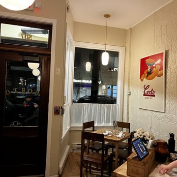 Corto - a woman sitting at a table in a coffee shop - Italian Near Me - Jersey City, New Jersey