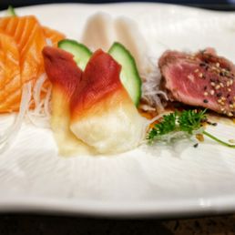 a variety of sushi on a white plate
