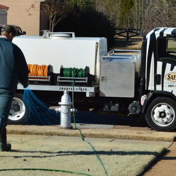 Safari Lawn Care - a man watering a lawn with a hose - Pest Control Near Me - Bartlett, Tennessee Safari Lawn Care - a man watering a lawn with a hose - Pest Control Near Me - Bartlett, Tennessee
